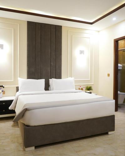 a bedroom with a large bed with white pillows at Faletti's Express Hotel Airport Lahore in Lahore