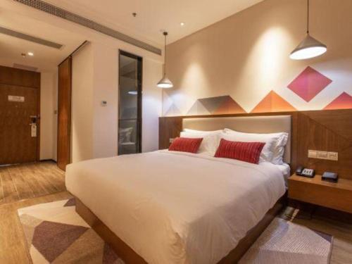 a bedroom with a large white bed with red pillows at Borrman Hotel Guilin Railway Station Two Rivers and Four Lakes in Guilin