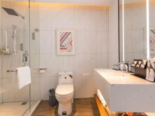 a bathroom with a toilet and a shower and a sink at Borrman Hotel Guilin Railway Station Two Rivers and Four Lakes in Guilin
