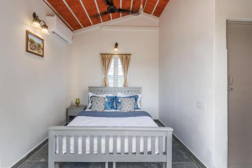 TalaiLakeside ParadisePrivate Pool3 CottagesLawn的一间卧室，有一张白色的床和一扇窗户