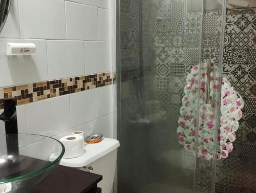 um banheiro com chuveiro, vaso sanitário e pia em Hostal Aurora Coronel em Concepción
