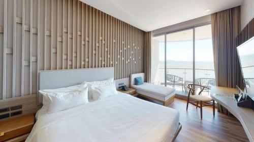 a bedroom with a large white bed and a balcony at Symphony of The Sea Hotel in Ban Thai Don (2)