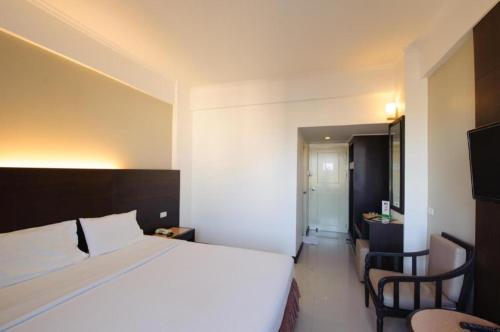 a hotel room with a bed and a table and chairs at Cathay Hotel in Betong