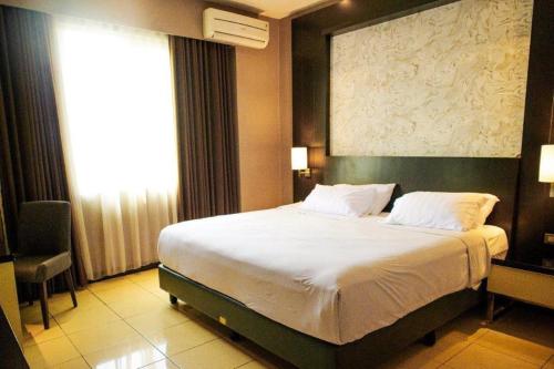 a bedroom with a large bed in a room at Karlita Hotel Tegal in Tegal