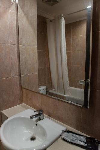 a bathroom with a sink and a mirror at Karlita Hotel Tegal in Tegal