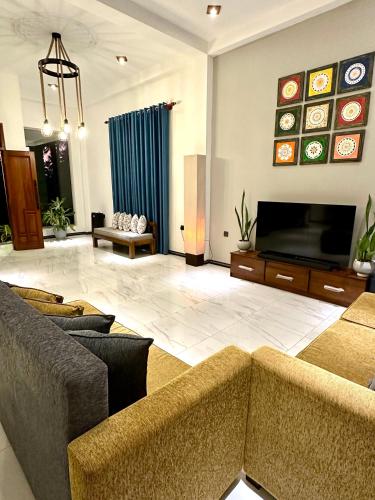 a living room with two couches and a flat screen tv at The Green Heaven Villa in Ambalangoda