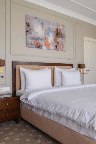 a bedroom with a large bed with white pillows at Almaty Hotel in Almaty