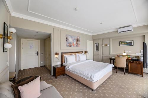a large hotel room with a bed and a desk at Almaty Hotel in Almaty