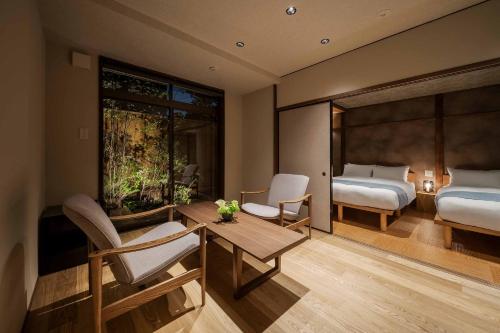 Un dormitorio con una cama y una mesa y sillas. en Suiki Machiya House, en Kanazawa