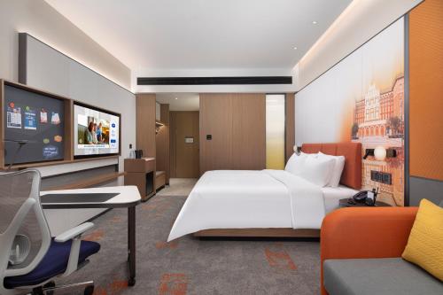a bedroom with a bed and a desk and a tv at 北京传媒大学希尔顿欢朋酒店Hampton by Hilton Beijing Communication University in Beijing