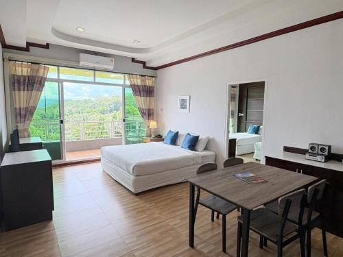a bedroom with a bed and a table and a bed and a window at Breeze Hill Resort in Campson