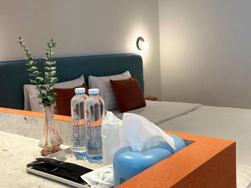 a room with a bed and two bottles on a table at 777Bliss Hometel in Nakhon Phanom