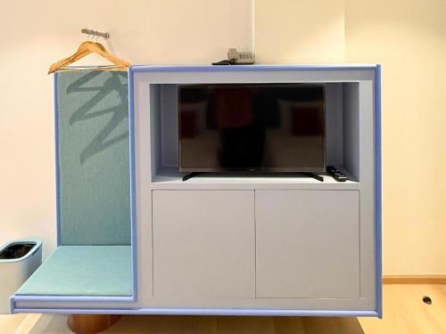 a tv on top of a white cabinet at 777Bliss Hometel in Nakhon Phanom