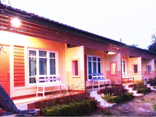 a house with two benches on the front of it at BanRai ChernMa Resort in Tak