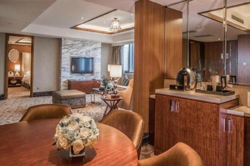 une chambre avec une table, une cuisine et un salon dans l'établissement Kun Tai Glory Hotel Beijing Wangjing, à Pékin