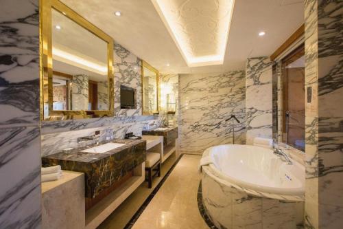 une grande salle de bain avec deux lavabos et une baignoire dans l'établissement Kun Tai Glory Hotel Beijing Wangjing, à Pékin