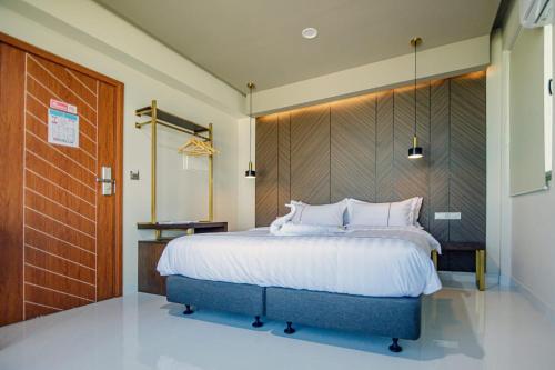 a bedroom with a large bed with a wooden headboard at Royal Villa Fulidhoo in Fulidu