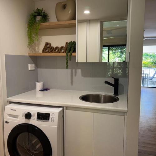 a kitchen with a washing machine and a sink at Noosa Keys Apartments in Noosaville