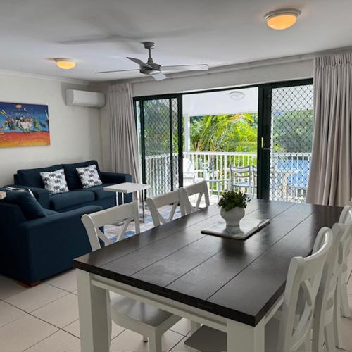 a living room with a table and a couch at Noosa Keys Apartments in Noosaville