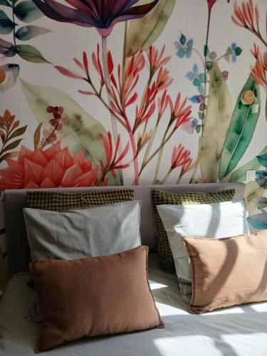 a bedroom with a floral wallpaper and a bed with pillows at La Parenthèse Comtoise in Dole