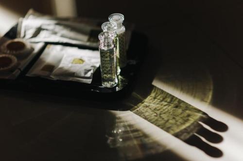 a glass bottle sitting on top of a table at Aramis Hotel in Nakhon Sawan