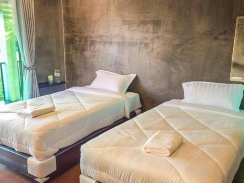two beds sitting next to each other in a bedroom at So Herbs at Home in Chiang Rai