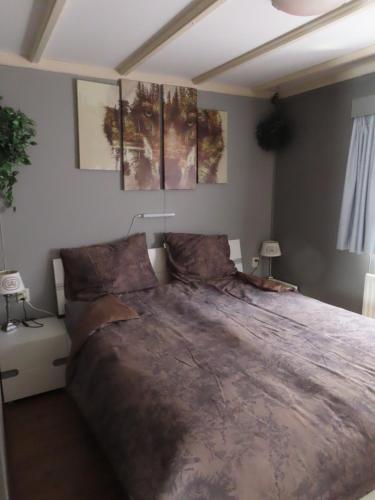 a bedroom with a large bed in a room at Veluwe Park Reewold Chalet Eclipse in Putten