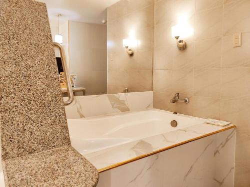 a white bath tub in a bathroom with a mirror at One Serenata Hotel General Trias in Silang