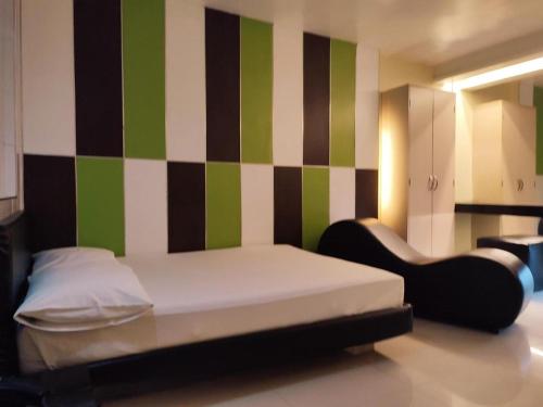 a bedroom with a bed and a green and white wall at One Serenata Hotel General Trias in Silang