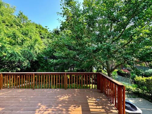 a wooden deck with a tree and some trees at Charming 3 Bedroom Home In Richmond Hill in Richmond Hill