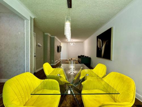 a dining room with yellow chairs and a glass table at Charming 3 Bedroom Home In Richmond Hill in Richmond Hill