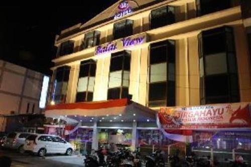 a building with a car parked in front of it at Balai View Hotel in Tanjung Balai Karimun