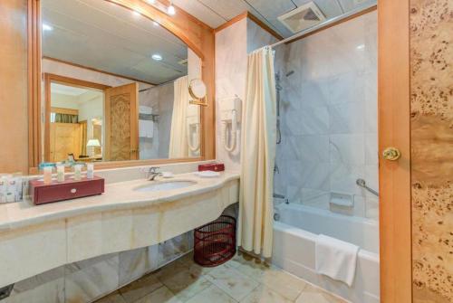 a bathroom with a sink and a shower and a tub at Zhuhai Dehan Hotel in Zhuhai