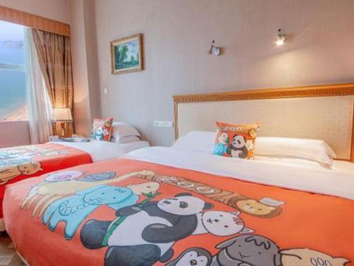 a bedroom with two beds with cartoon animals on it at Zhuhai Dehan Hotel in Zhuhai