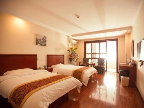 a hotel room with two beds and a desk at GreenTree Inn Lianyungang Guanyun Bus Station Zhenxing Garden Express Hotel in Guanyun
