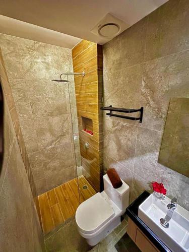 a bathroom with a toilet and a shower and a sink at Delta Chenang Resort in Pantai Cenang