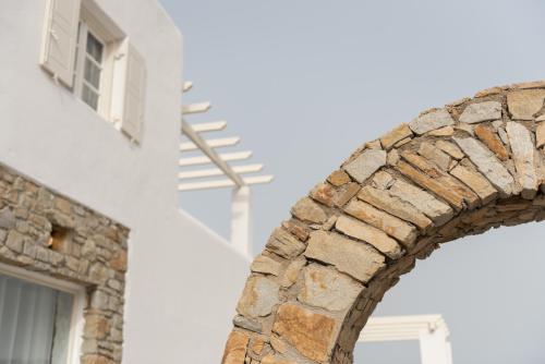 a brick archway in front of a building at Cova Mykonos Suites in Elia Beach