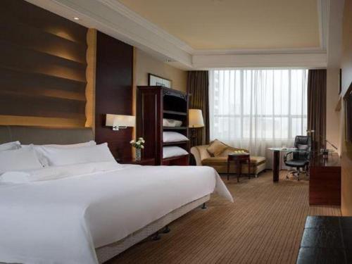 une chambre d'hôtel avec un grand lit et un bureau dans l'établissement Venus Royal Hotel （Kirin Parkview Hotel）, à Shatsing