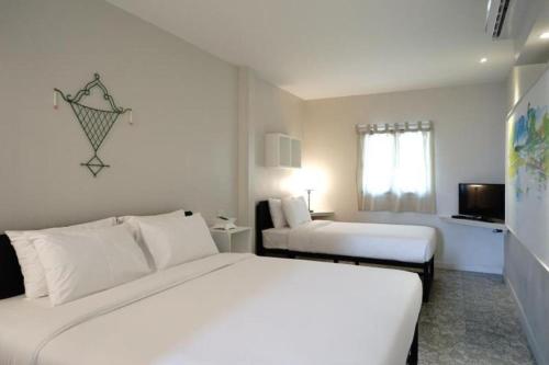 une chambre d'hôtel avec deux lits et une télévision dans l'établissement Silp-Pa Phra Nakhon Si Ayutthaya Hotel, à Phra Nakhon Si Ayutthaya