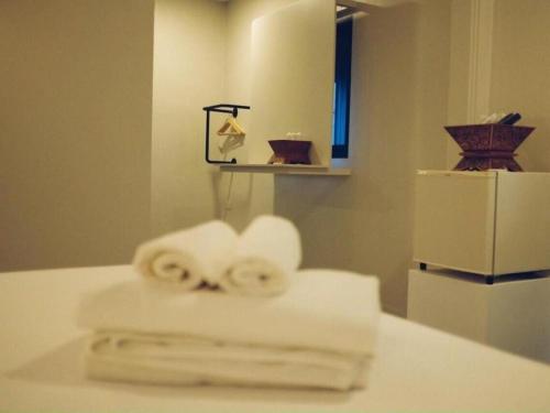 une pile de serviettes assises sur un comptoir dans la salle de bains dans l'établissement Silp-Pa Phra Nakhon Si Ayutthaya Hotel, à Phra Nakhon Si Ayutthaya