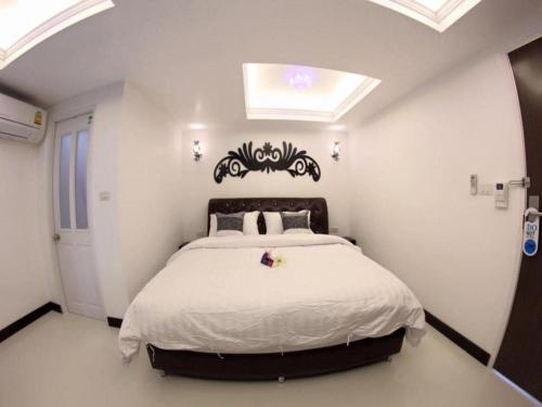 a bedroom with a large bed with a black headboard at Samranchaykhong Hotel in Mukdahan