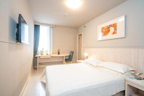a bedroom with a bed and a desk and a television at Jinjiang Inn Xi'an Dayan Tower Xiaozhai Metro Station in Xi'an