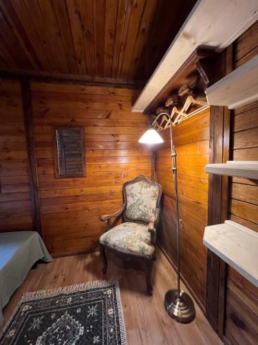 a room with a chair and a lamp in a cabin at Haus am See in Mühldorf