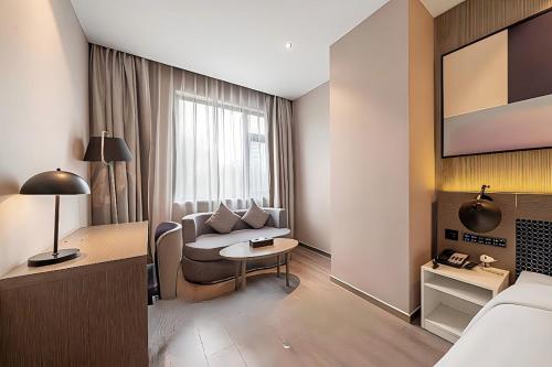 a hotel room with a couch and a table at Jinglai Hotel Changshou Road Subway Station Branch in Shanghai