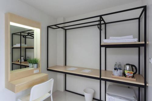 a room with a shelf and a mirror at Le Park Hotel in Nakhon Si Thammarat