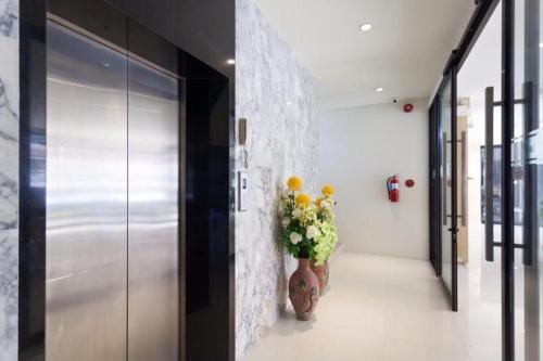 a hallway with a vase with flowers in it at Le Park Hotel in Nakhon Si Thammarat