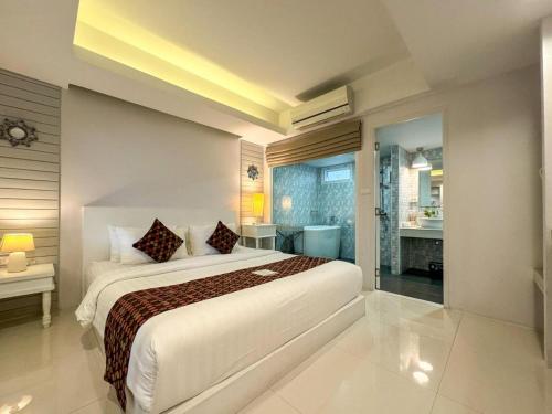a bedroom with a large bed and a bathroom at NanNakara Boutique Hotel in Nan