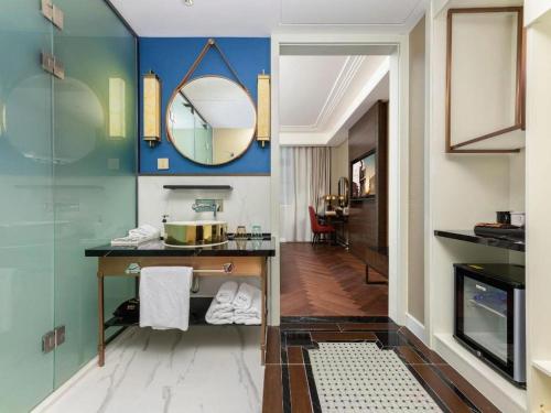 a bathroom with a sink and a mirror at Metropolo Hotel Hefei Baohe Wandabao Park Metro Station in Hefei