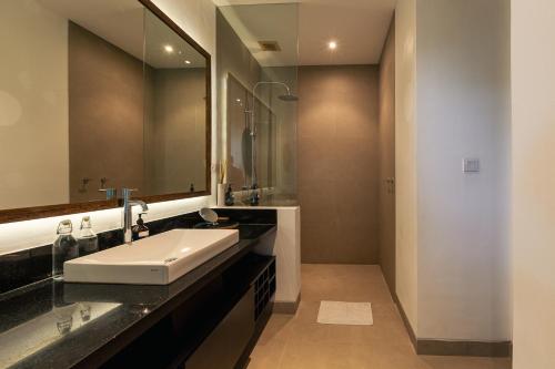 une salle de bain avec un lavabo et un miroir dans l'établissement Beachfront Villa in Bali, à Cemagi