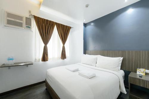 a bedroom with a large white bed and a window at Eighty Eight Hotel in Koronadal